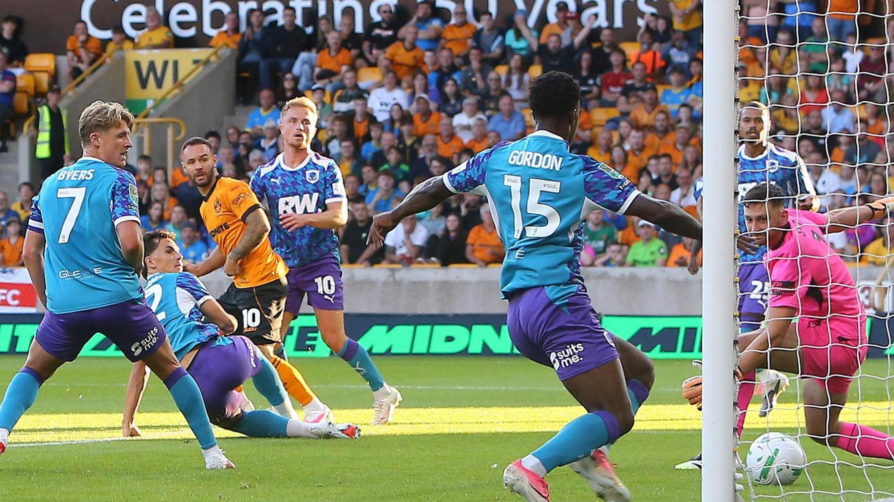 The Port Vale defence are caught cold as Adam Armstrong watches Wolves' first goal of the season cross the line