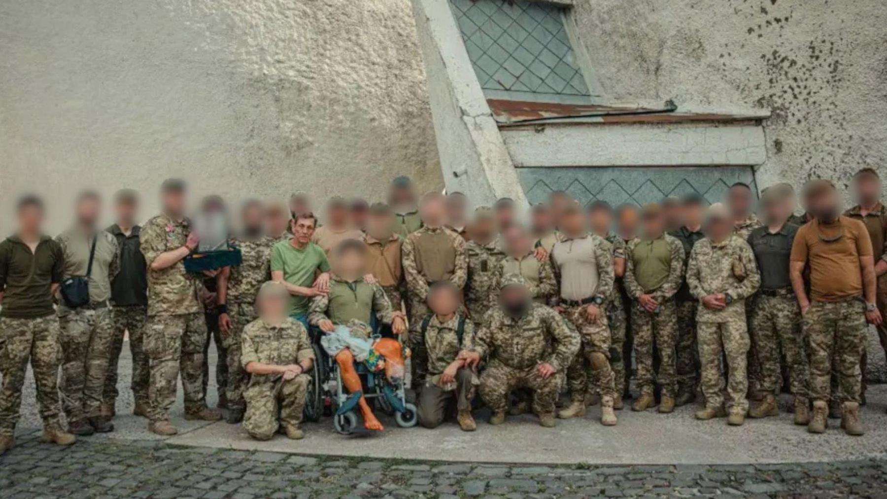 Group shot of soldiers with blurred faces and one unblurred, which is James's father