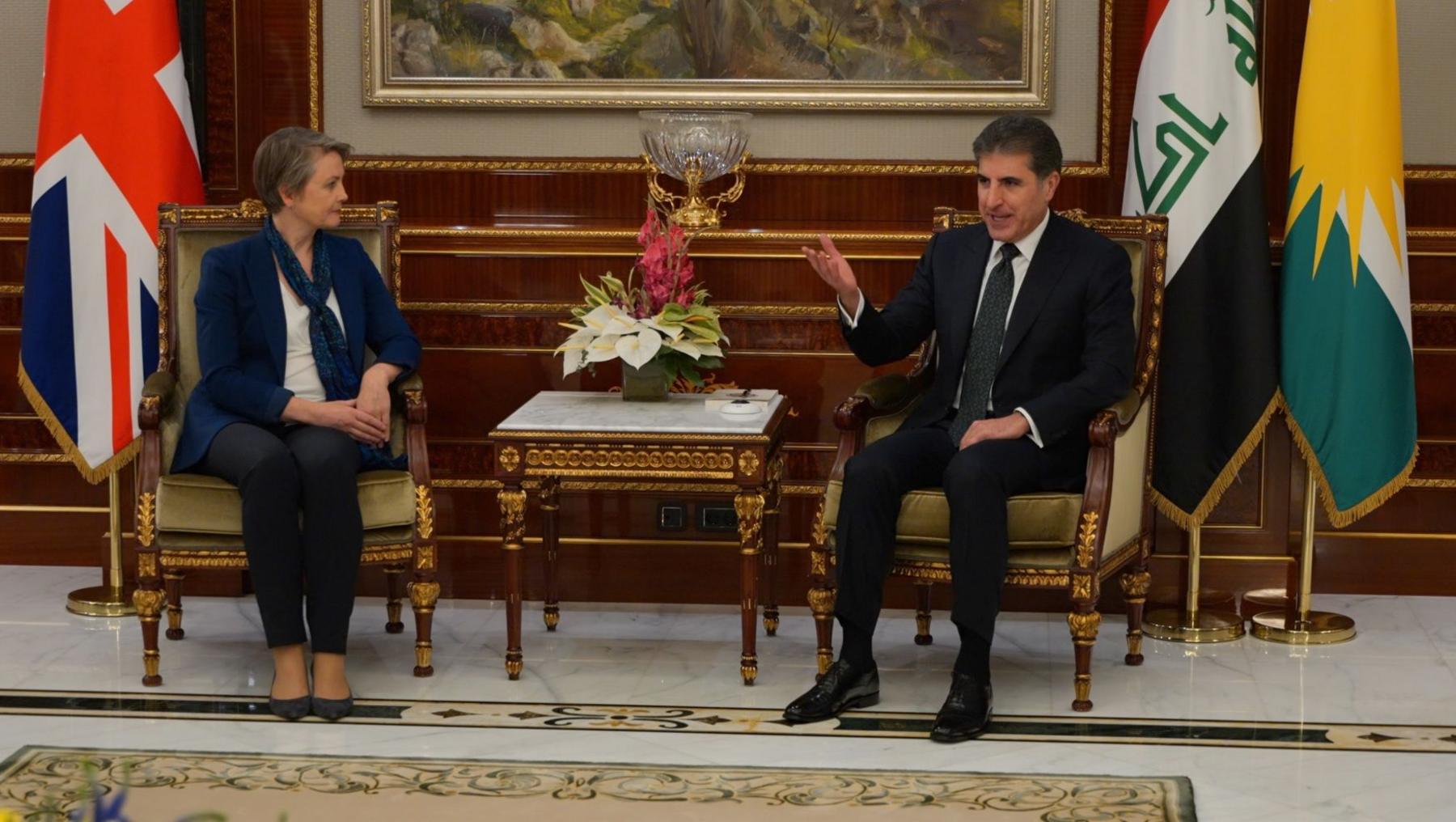 Yvette Cooper and Nechirvan Barzani sitting on chairs next to each other in front of the flags for the UK, Iraq and the Kurdistan region.