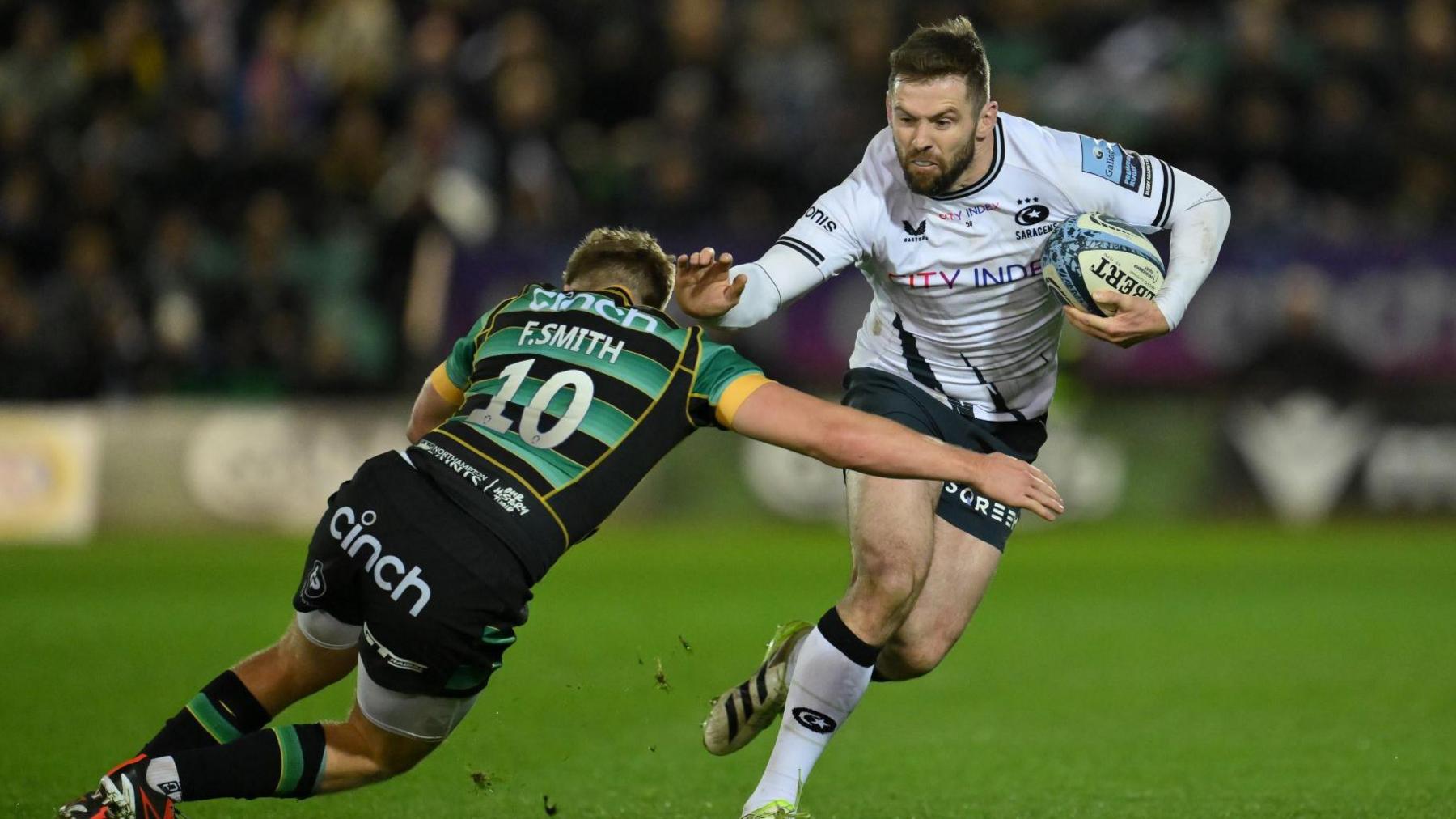 Elliot Daly fends off a tackle from Fin Smith