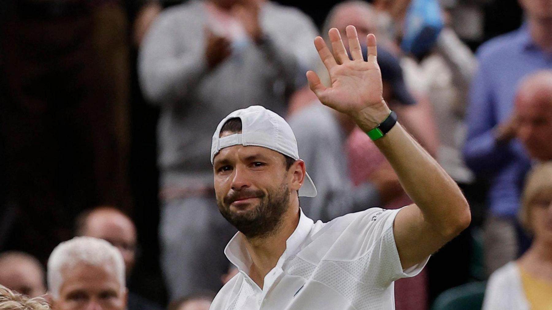 Grigor Dimitrov looks upset as he waves to Centre Court crowd following retirement from his last-16 match against Jannik Sinner at Wimbledon