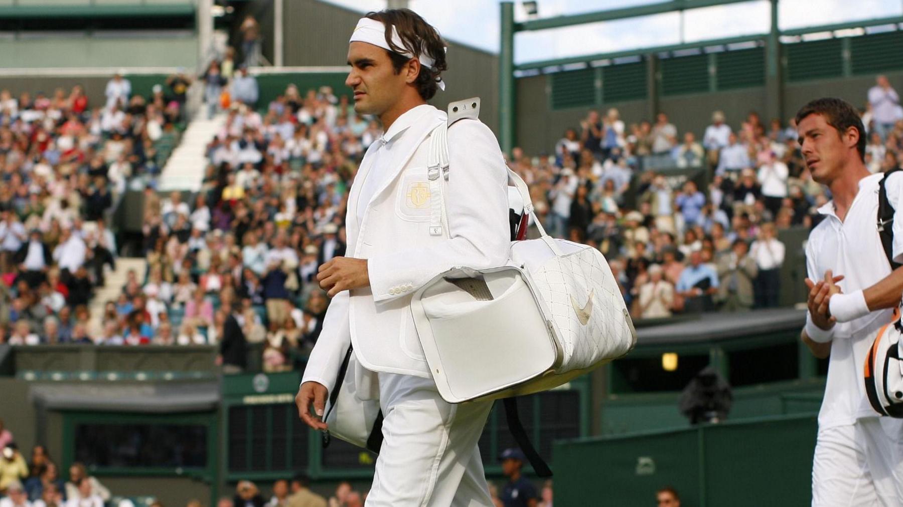 Roger Federer (L) and Russia's Marat Safin (R) enter the court at Wimbledon in 2007