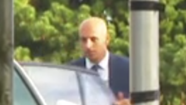 Dr Raed Al-Mobayed, wearing a jacket, collar and tie, near a car, and seen from a distance