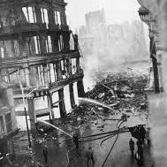 Black and white photograph of firemen extunguishing the fire which destroyed the Ben Evans department store in Swansea. Two fire hoses aiming water at the building. Much of Swansea's iconic architecture was destroyed during the Blitz 