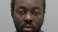 Tyreese Kamau: A man with black hair and a black beard wearing a grey,round-necked t-shirt