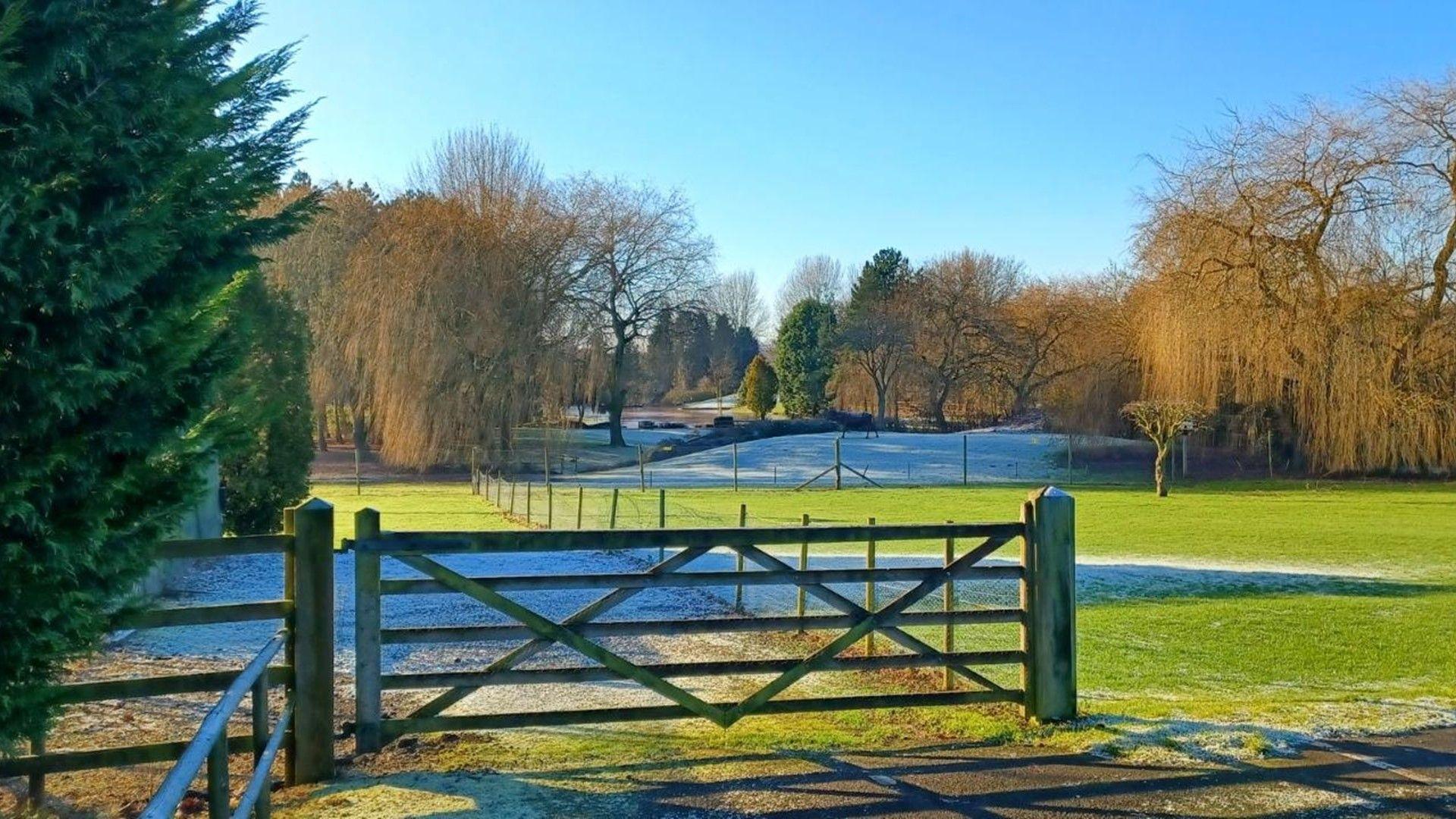 A sunny rural scene with snow and ice remaining in shaded areas