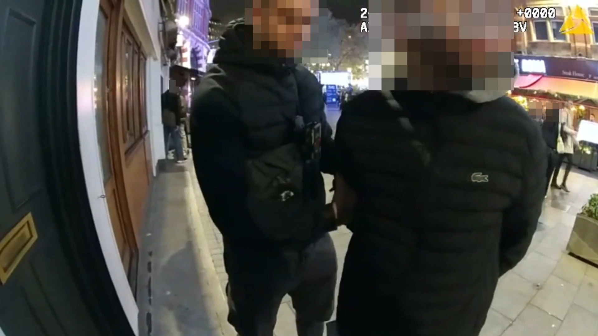 A man being arrested in London's West End. His face, and that of the officer, is blurred out