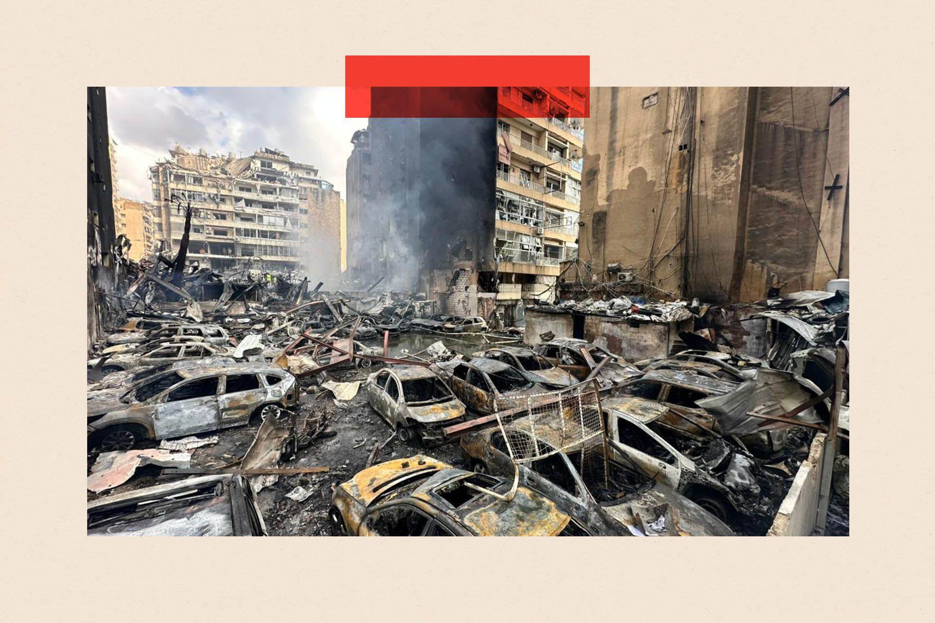 Emergency teams work at the scene where smoke rises from targeted locations across Lebanon - destroyed cars and buildings are shown
