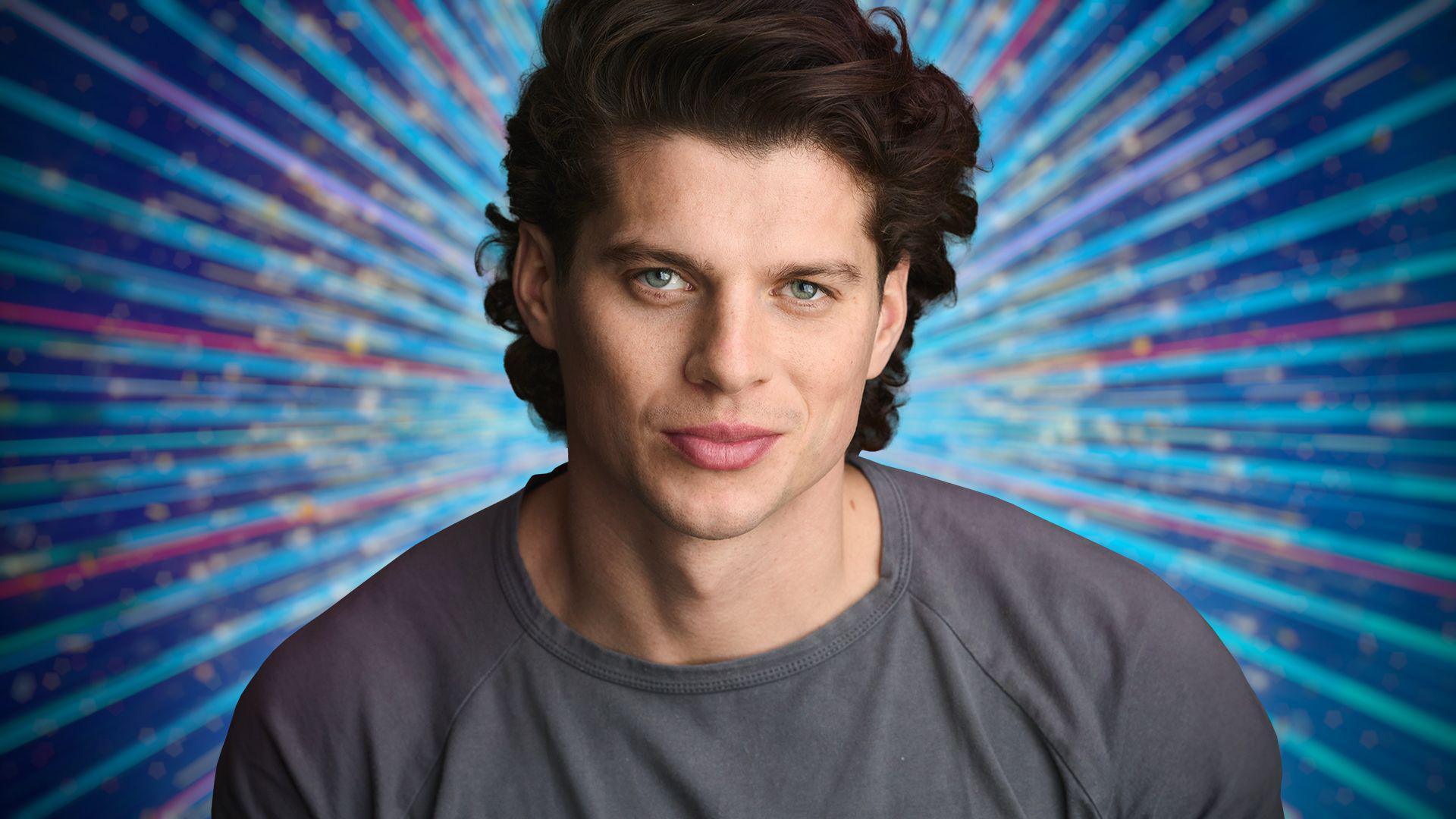 Lewis Cope looking at the camera, against a blue background