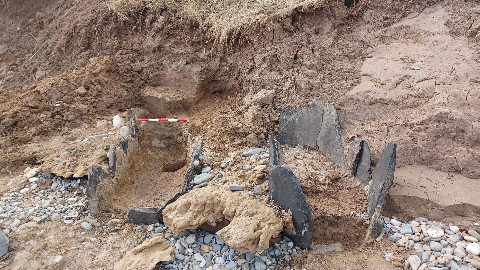 A picture of two grave-like shapes with slates on either side 