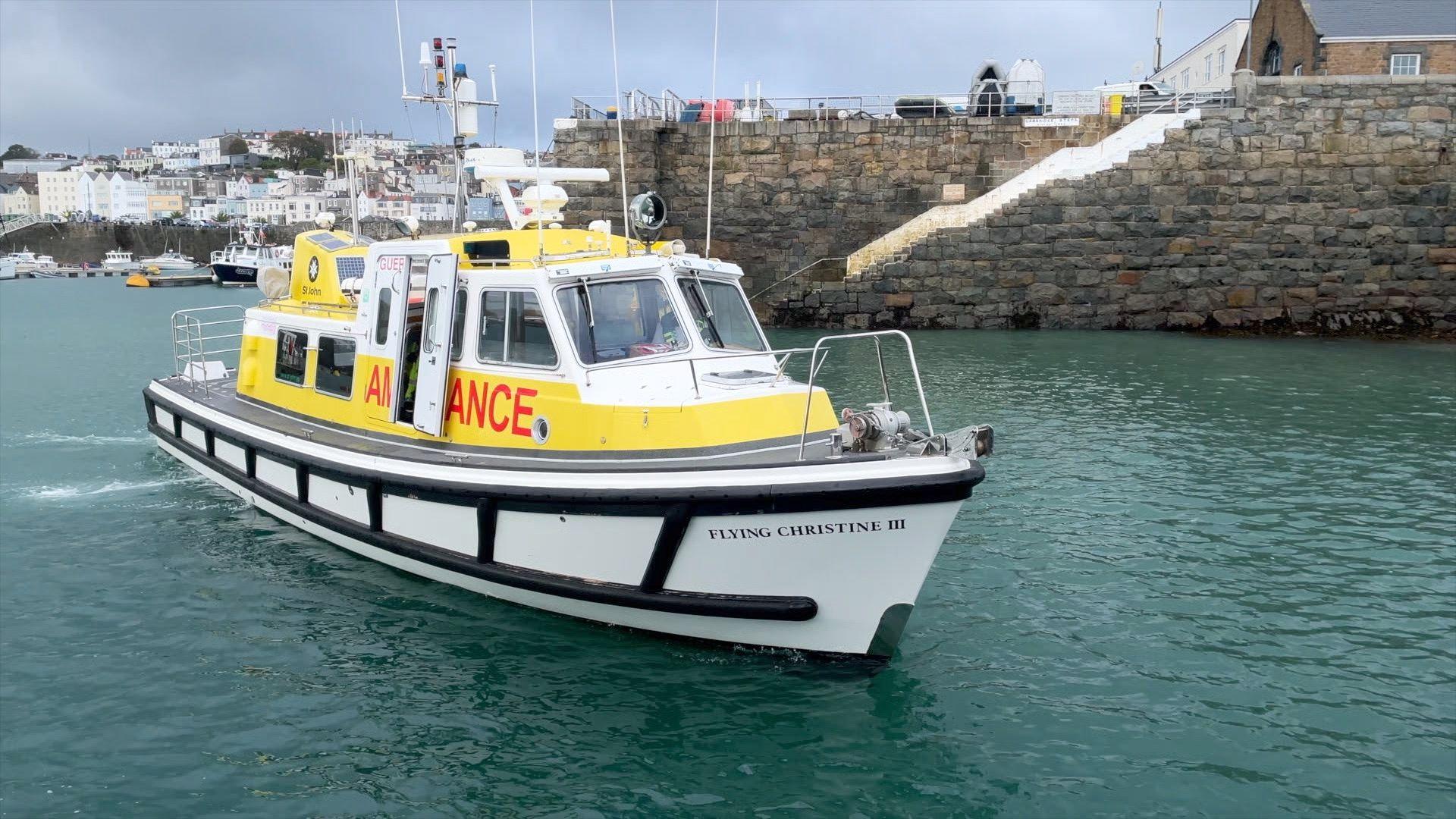A white and yellow boat in sea with a harbour wall and steps
