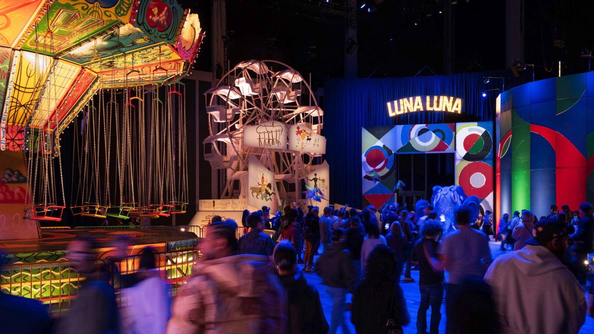 Visitors to Luna Luna's exhibits are blurred as they rush past the rides.