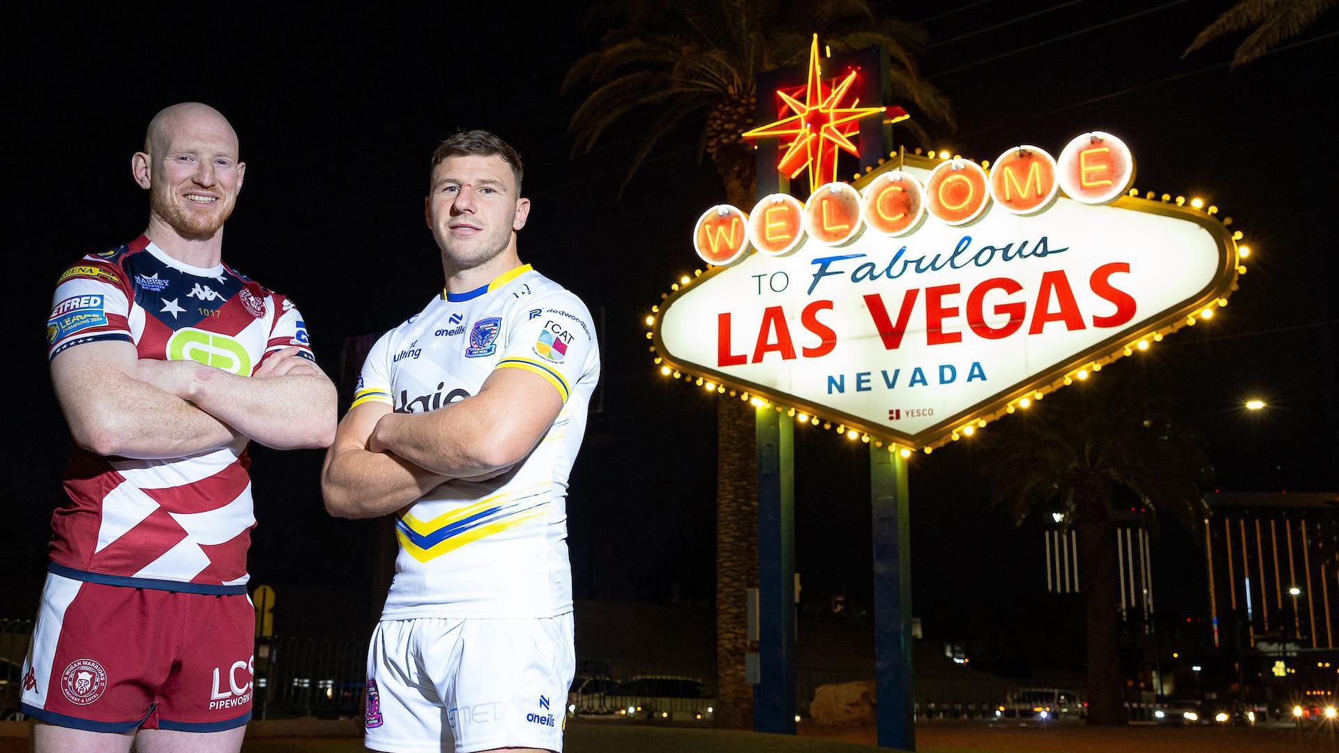 Wigan Warriors captain Liam Farrell and Warrington Wolves captain George Williams stand beside the Welcome to Fabulous Las Vegas sign