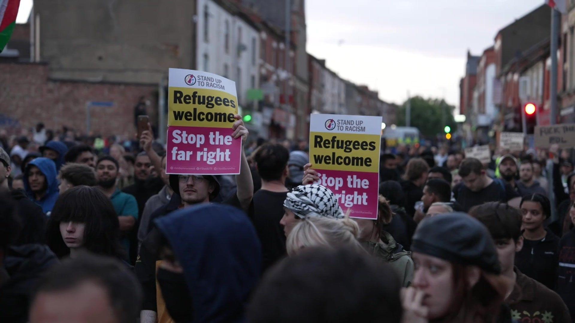 Northampton counter-protesters gathered and hold signs saying "Refugees welcome: Stop the far right"