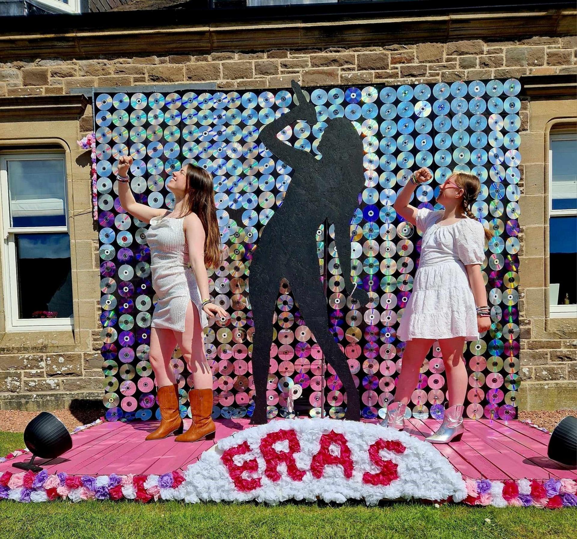 Abigail, 19 and Jessica, 9, at their Taylor Swift CD backdrop