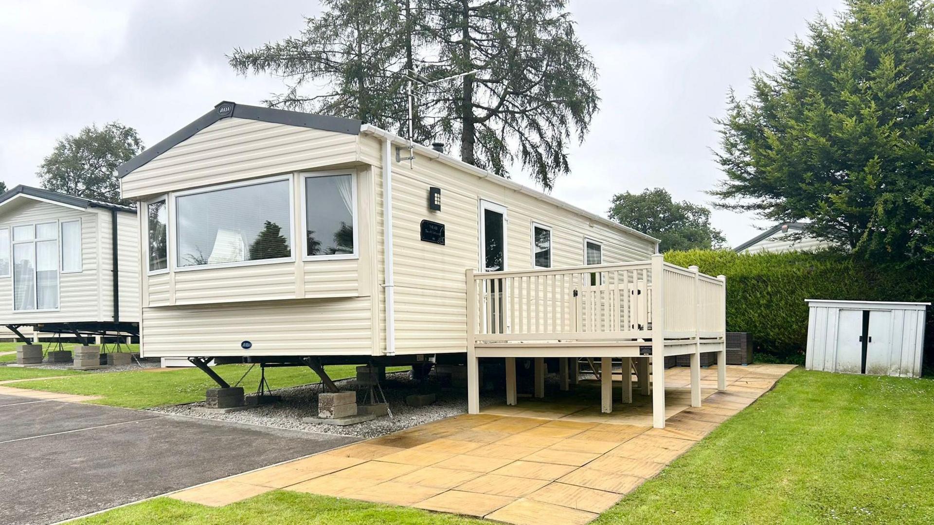 Jack and Lindsey Kitching's cream caravan is located next to a patch of grass on the holiday park. To the left is another caravan belonging to other owners.