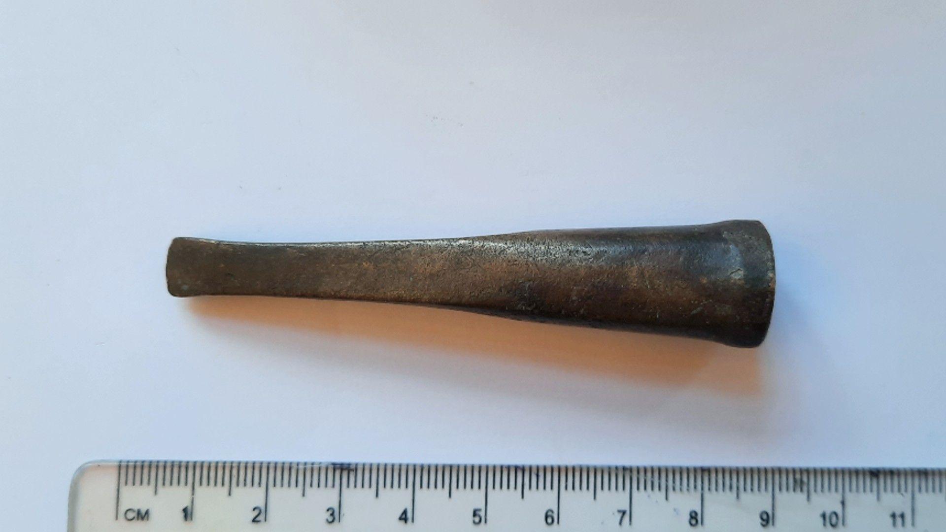 A Bronze Age chisel, with ruler to show its scale