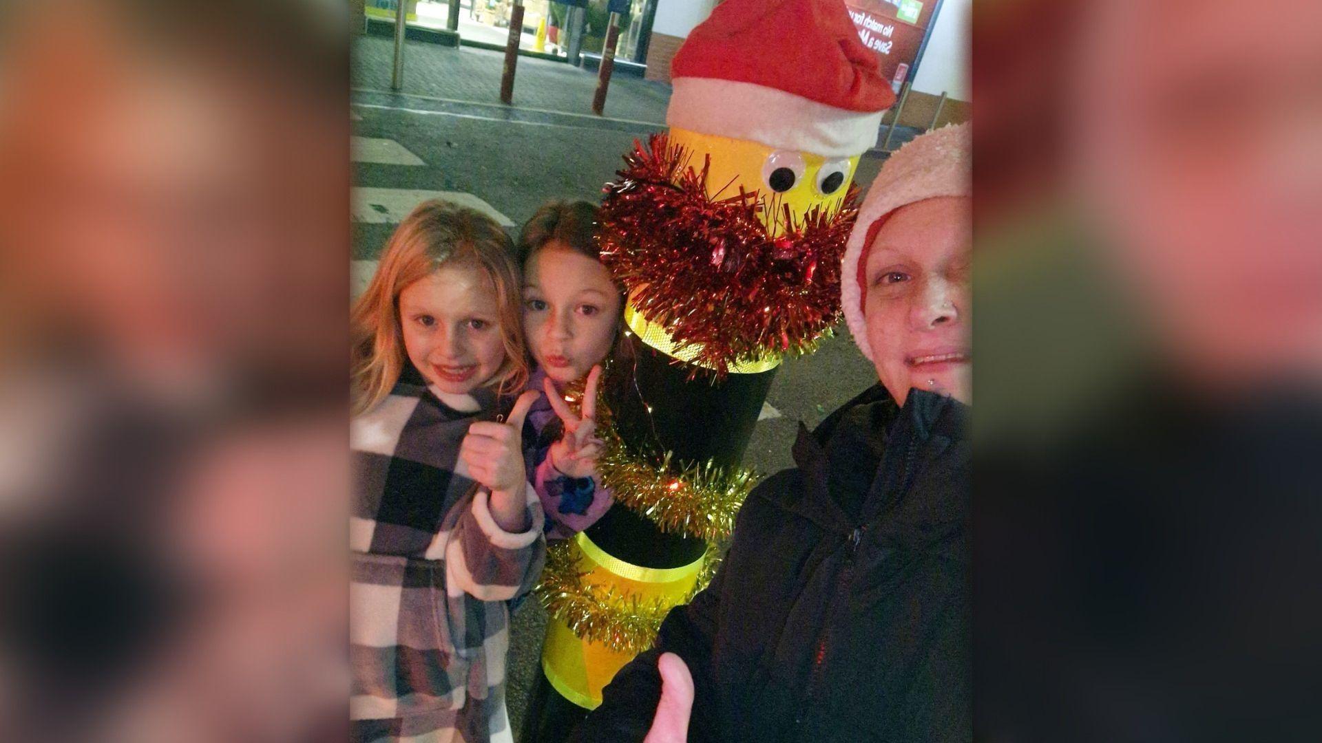 Rachael Snarr posing next to the bollard with her two children.