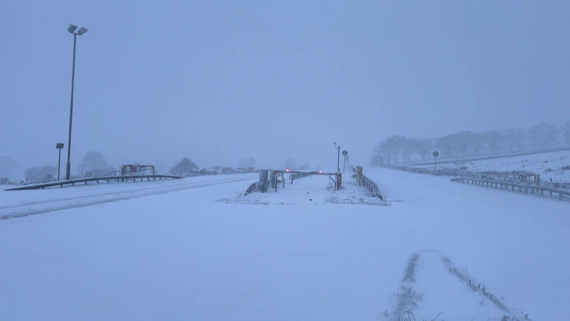 A road covered with snow with a white fog