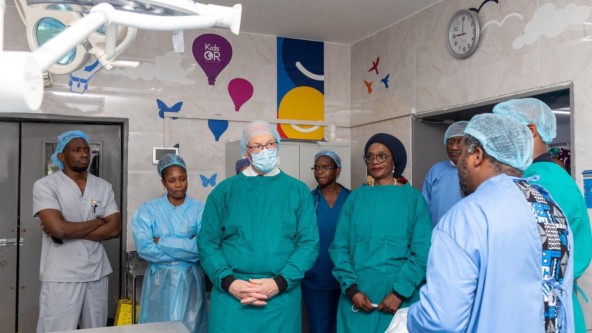 John Swinney stands in what appears to be an operating theatre, wearing a green overall