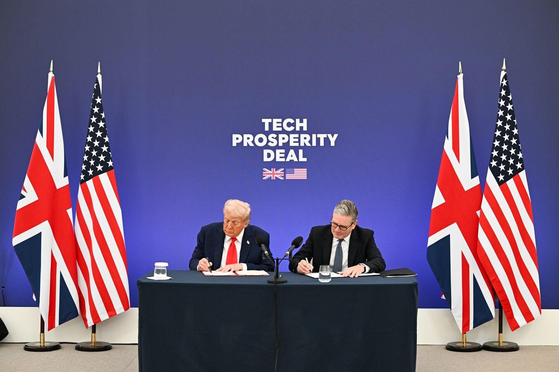 British Prime Minister Keir Starmer (R) and US President Donald Trump (L) sign the Tech Prosperity Deal during a business reception at Chequers, the country residence of the Prime Minister in Aylesbury, Britain