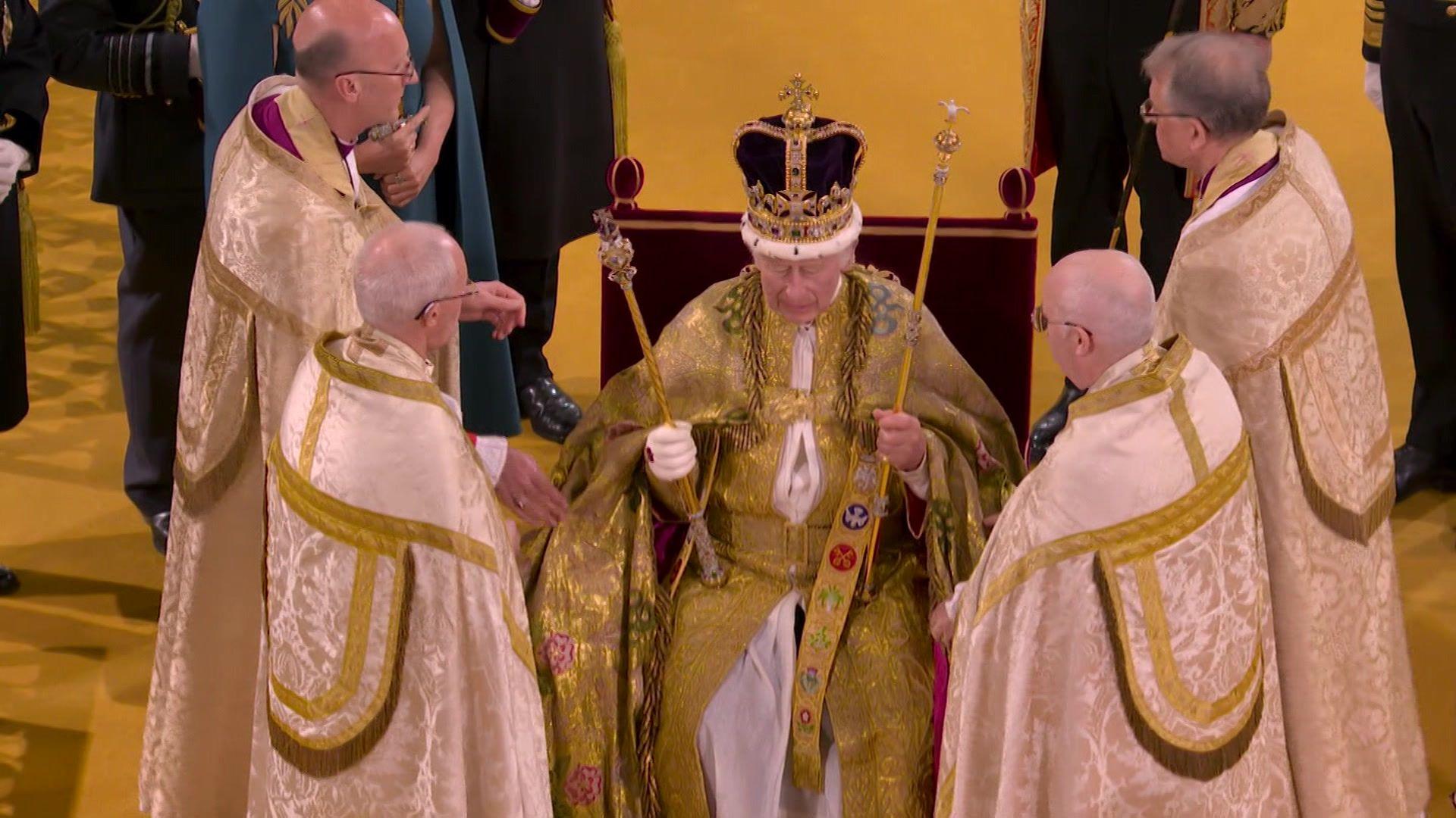 The King takes part in his coronation surrounded by clerics