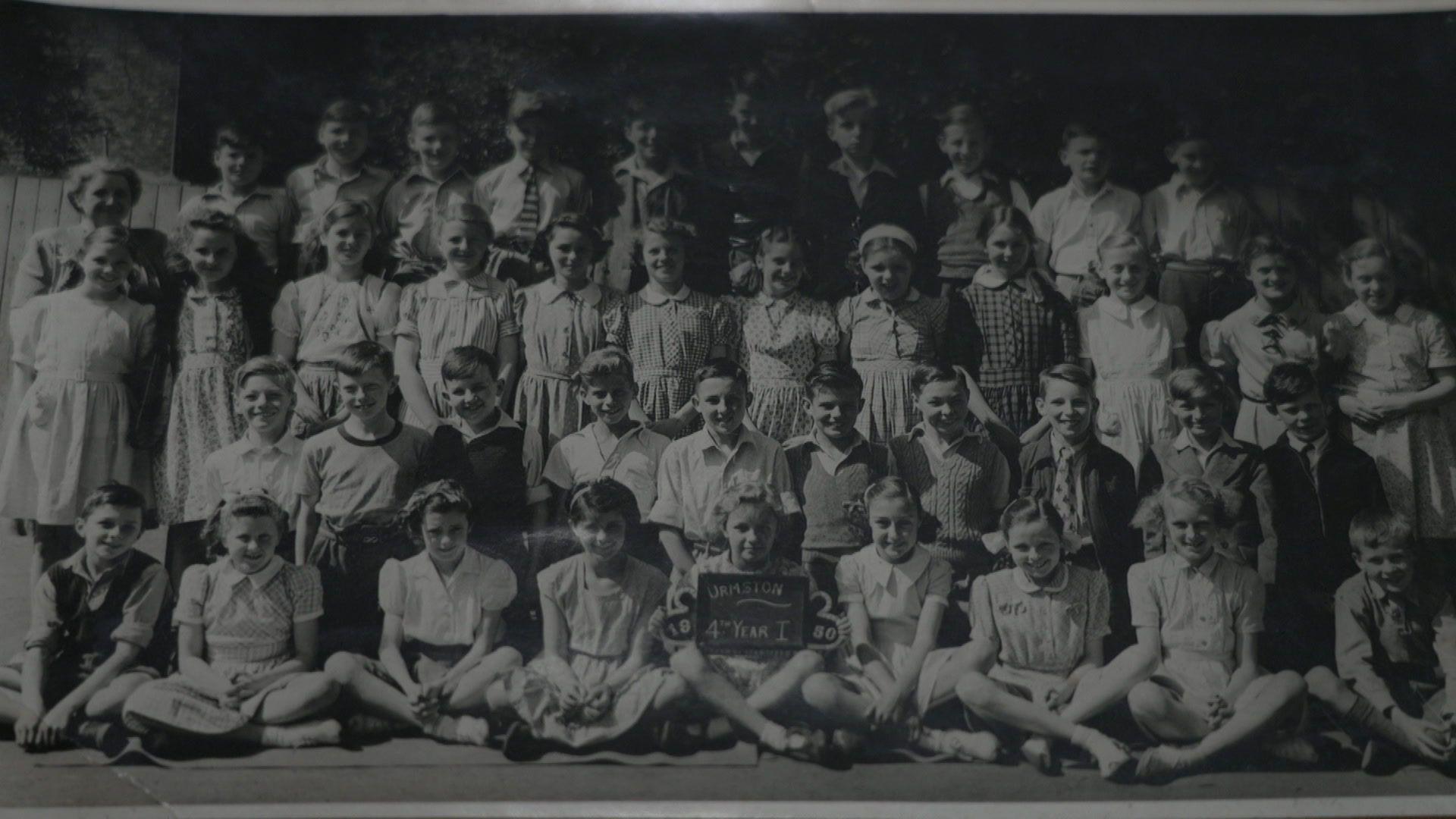 A black-and-white class photograph from Urmston Primary School in 1950. The children are arranged in four rows.