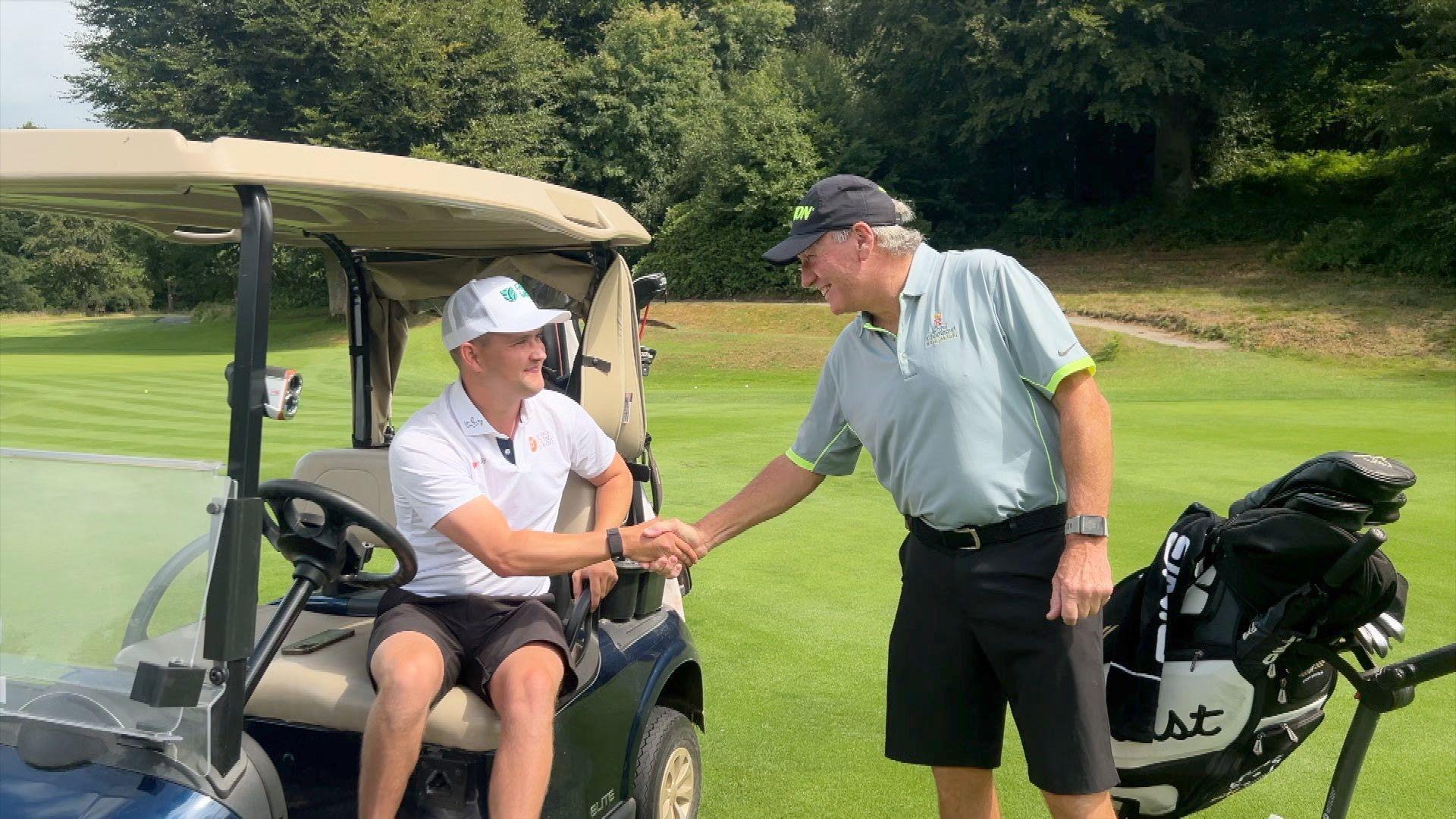 Kipp Popert shaking hands with a fellow member of the Wildernesse Golf Club in Sevenoaks on the green.