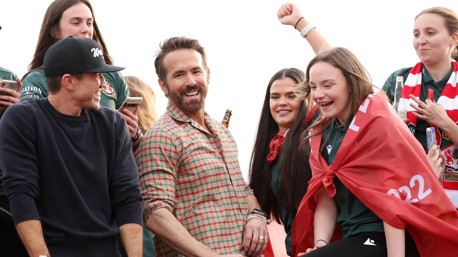 Lili yn dathlu gyda Ryan Reynolds a Rob McElhenney a chwaraewyr Wrecsam