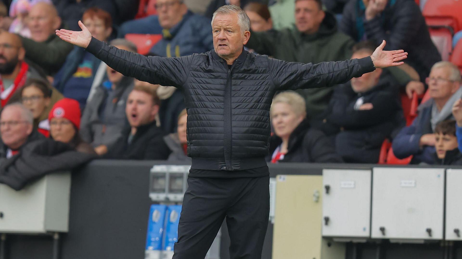 Chris Wilder, pictured with his arms outstretched on the touchline