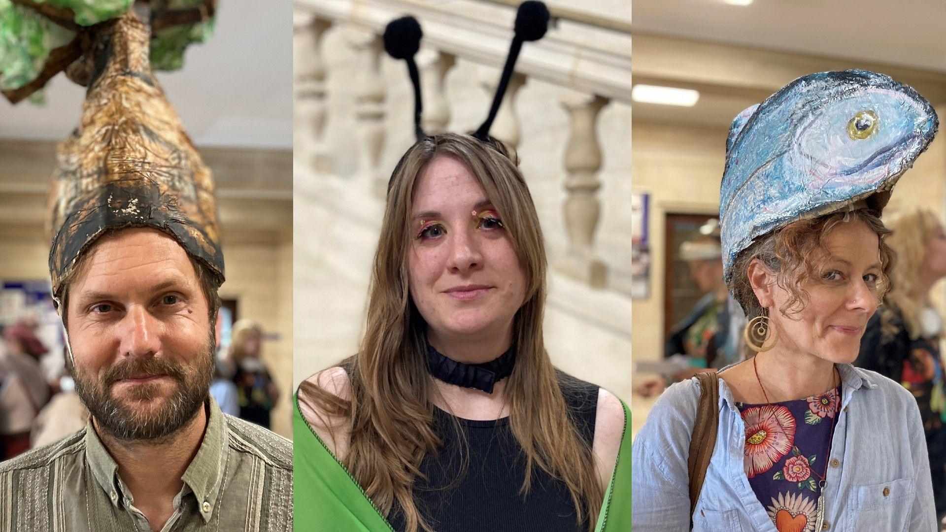 A man with a paper tree on his head on the left a woman dressed as a butterfly in the middle and a woman with a paper fish on her head on the right