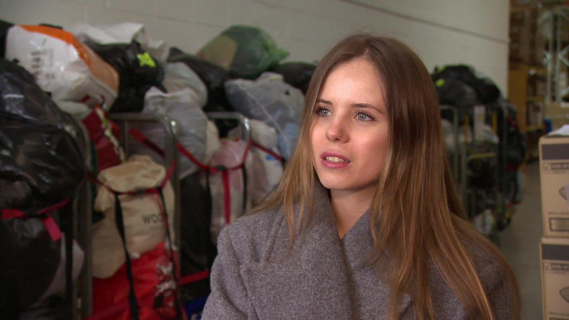 Kateryna Seranova standing in front of bags of donations