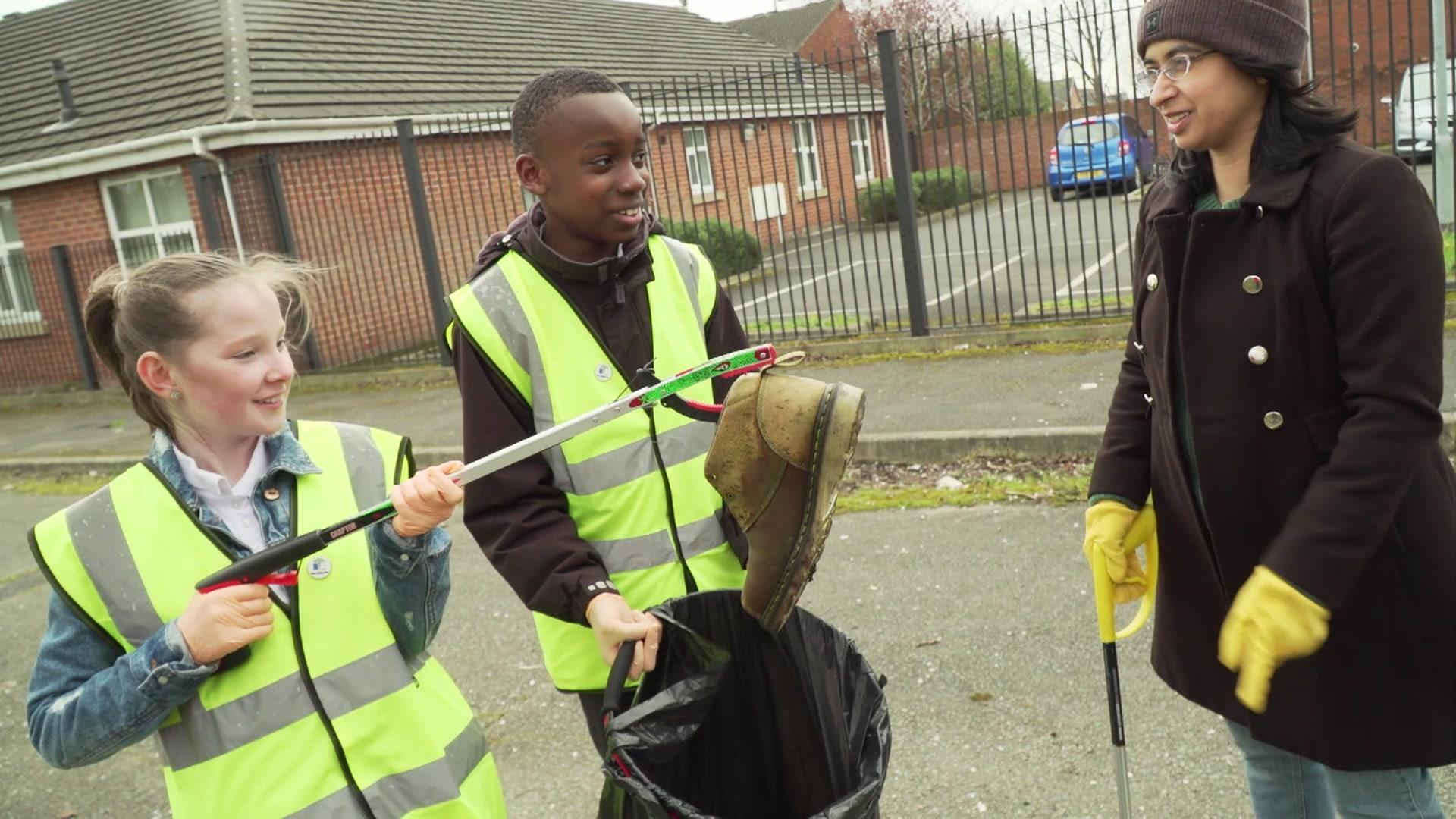 Litter pickers holding a discarded shoe