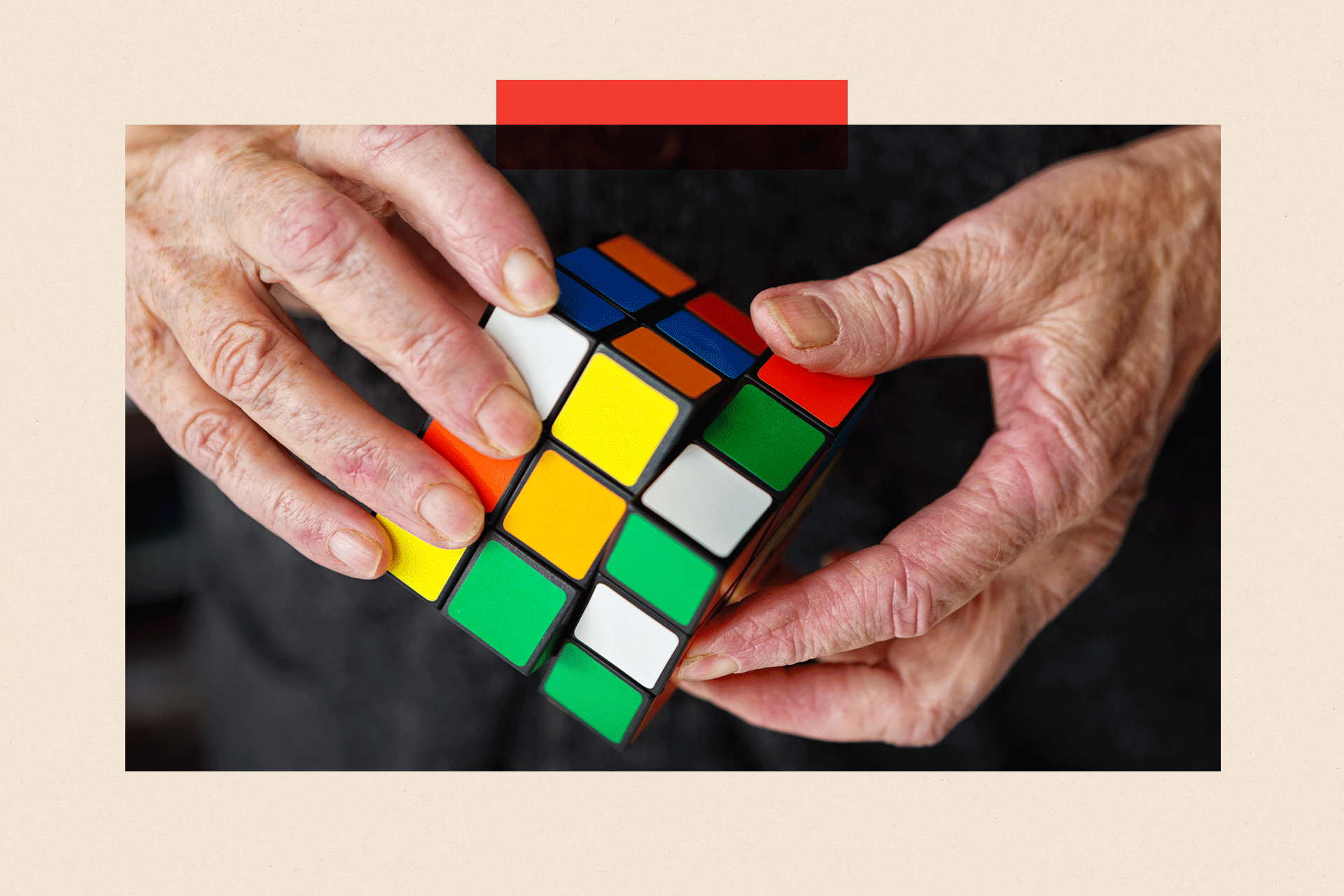 An elderly persons hands move a cube