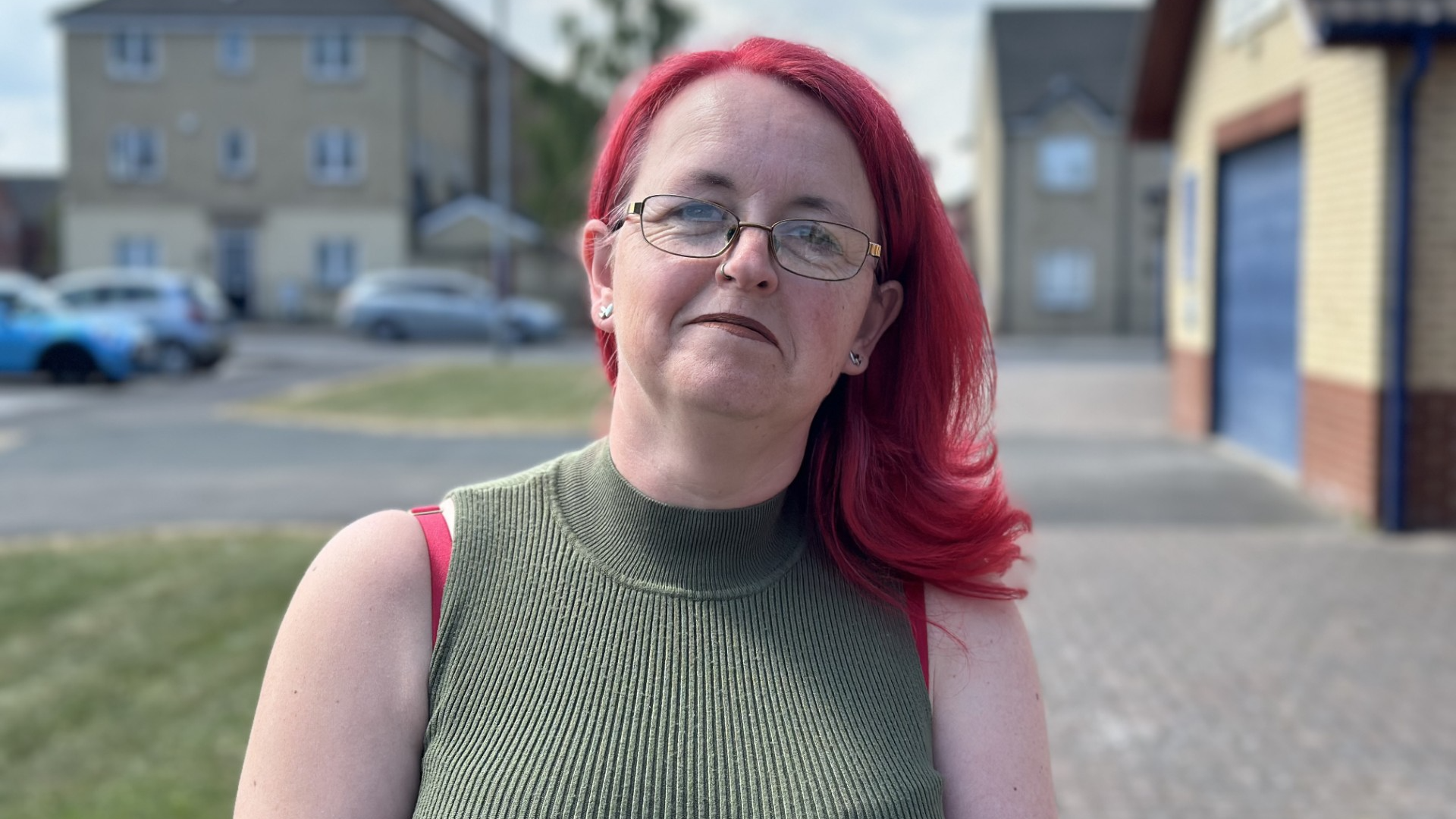Tracy McGuigan-Haigh smiles outside a housing area