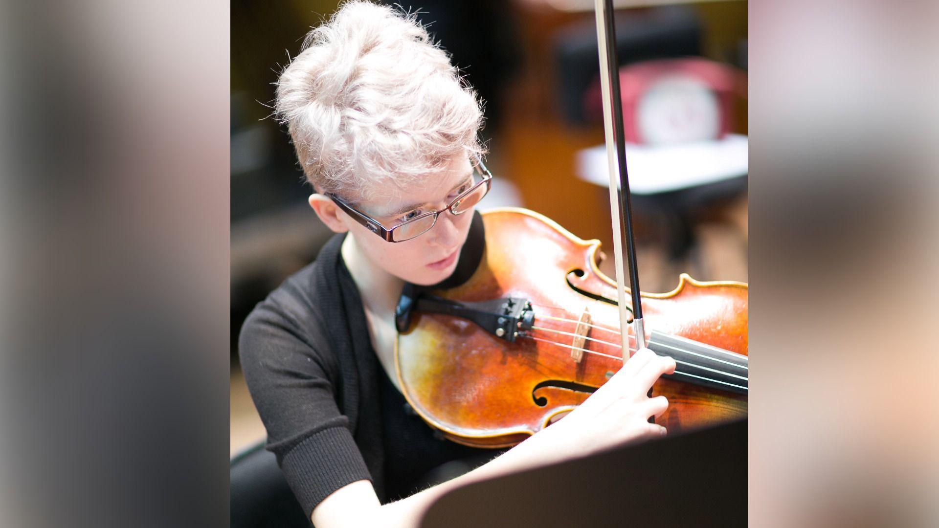Georgia Steel yn chwarae fiola mewn cerddorfa