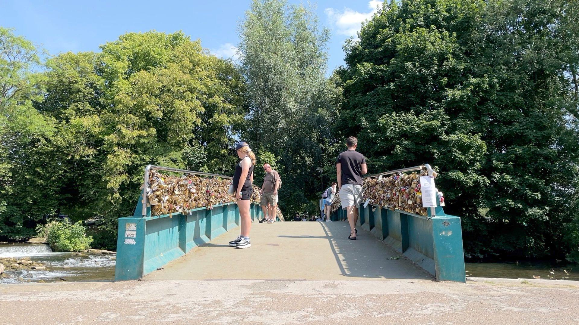 People looking at love locks on Weir Bridge in Bakewell