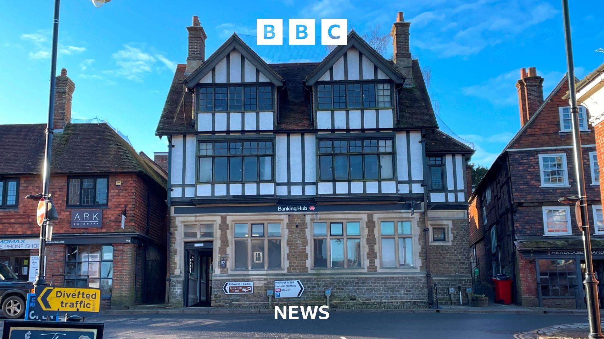 The exterior shot of the Haslemere banking hub which is sighted in an old bank on Haslemere High Street.  It is a 3 storey tudor building with a stone ground floor and other floors white with black beam work.