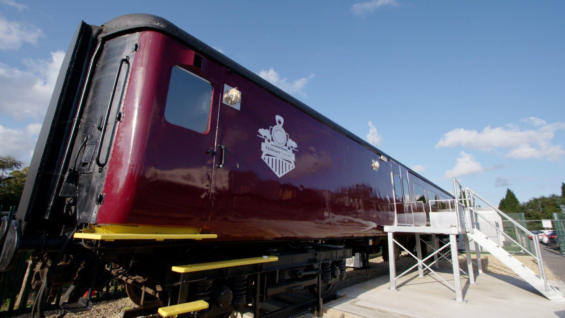 The outside of the redesigned train carriage, painted burgundy and gold