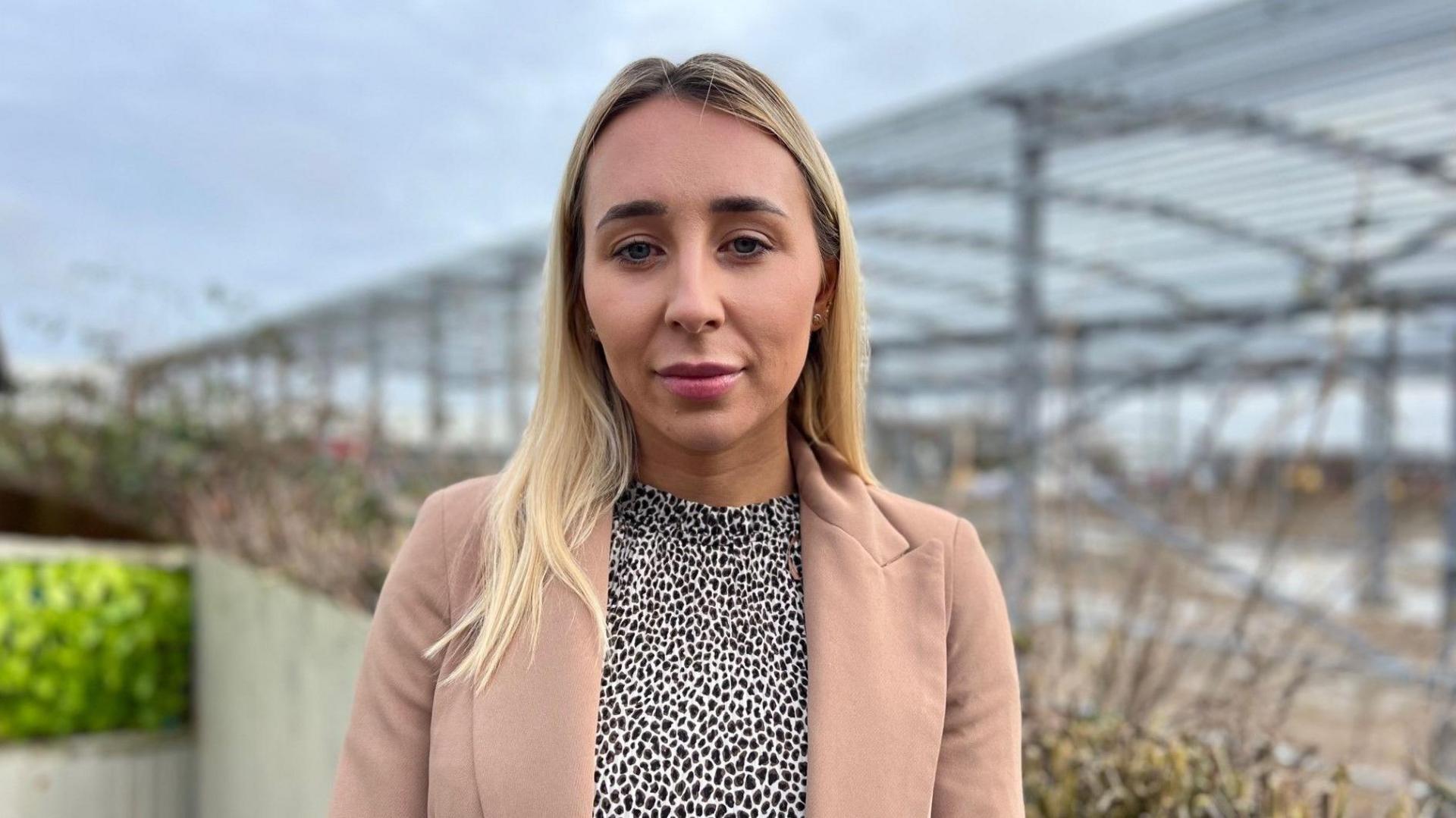 Georgie Wallis in her back garden with the warehouse in the background