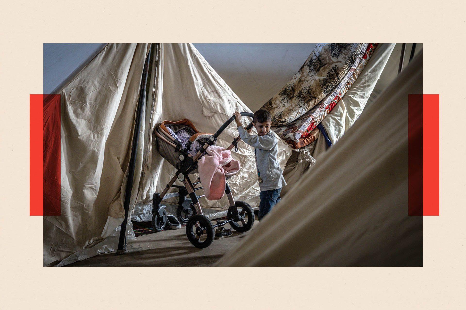 A displaced boy pushes a stroller into his family's tent at a temporary displacement camp inside the Beirut Stadium
