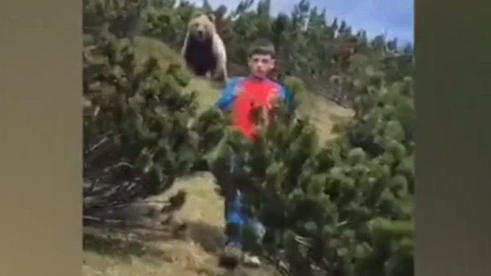 Boy with bear behind him