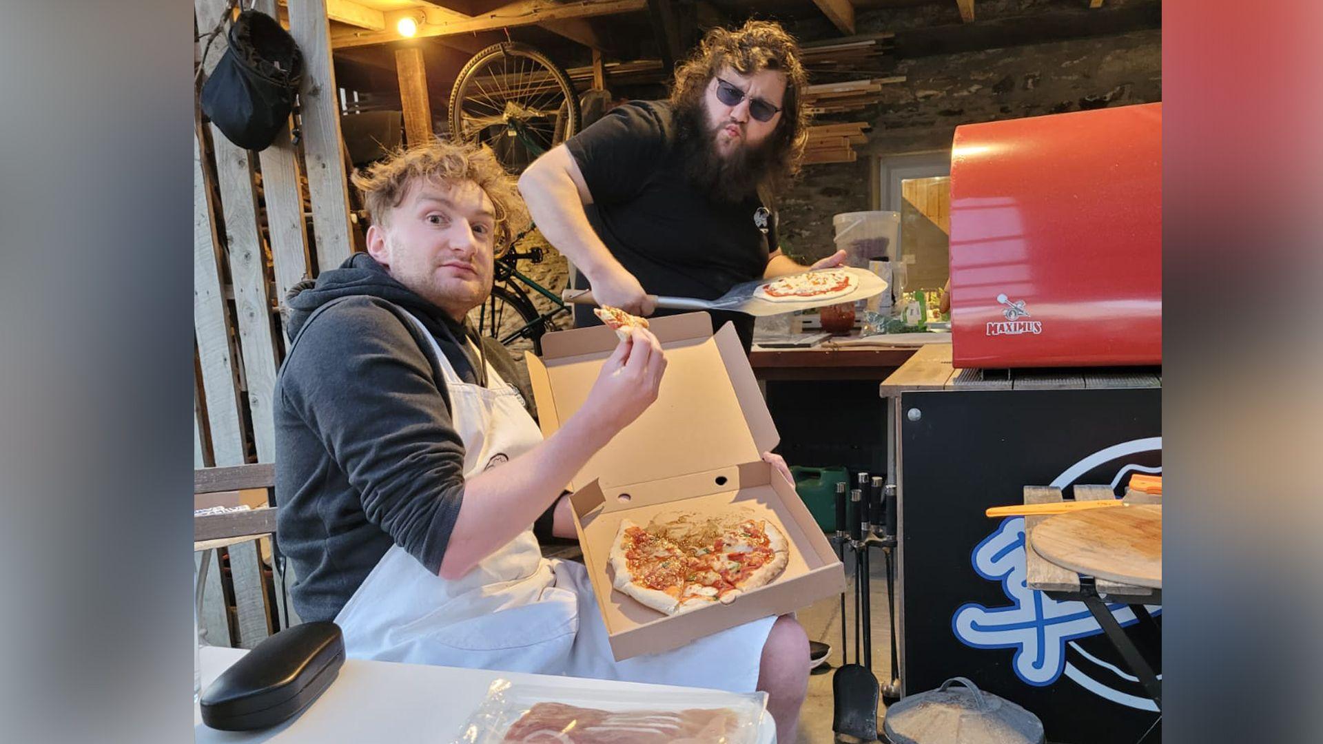 Carwyn gyda'i ffrind yn bwyta pizza
