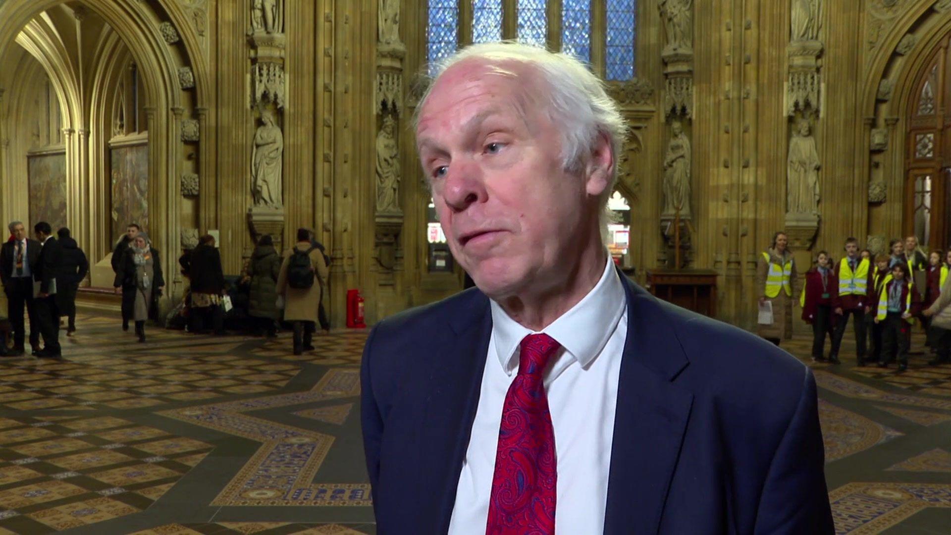 Scunthorpe MP Sir Nic Dakin standing in the entrance of the Palace of Westminster. He is wearing a blue suit jacket, white shirt and red tie.