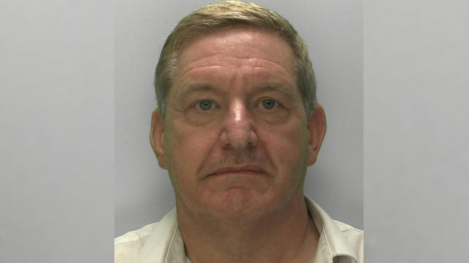 Police mugshot of offender Ashley Watson in custody wearing a pale yellow shirt and looking at the camera