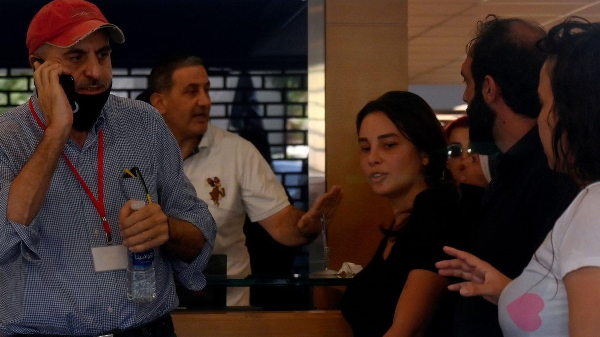 A woman identifying herself as Sally Hafez (centre) takes staff hostage at the Blom Bank branch in Beirut's Sodeco area on 14 September 2022