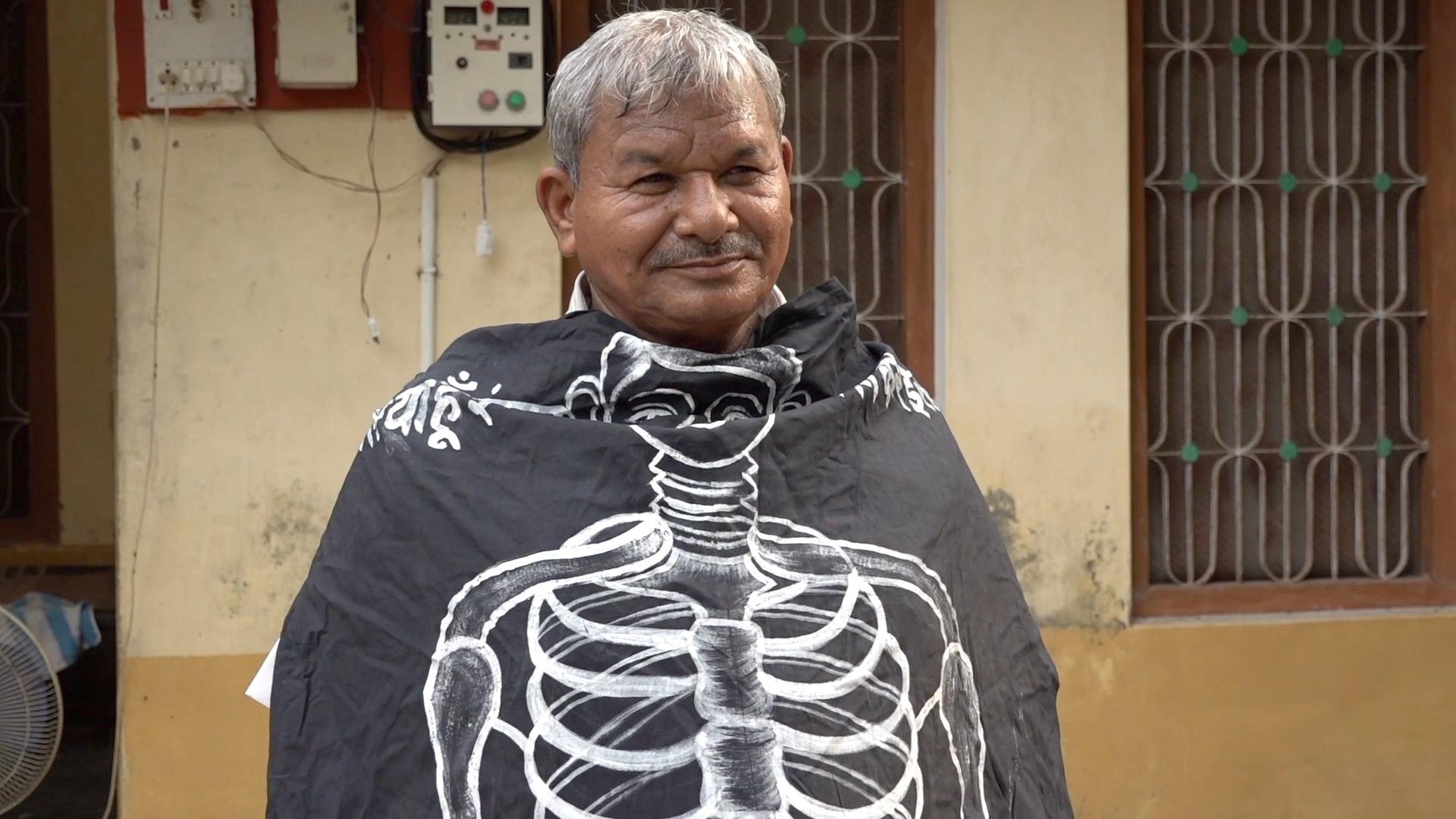 Lal Bihari Mritak wrapped in an Association of the Living Dead banner