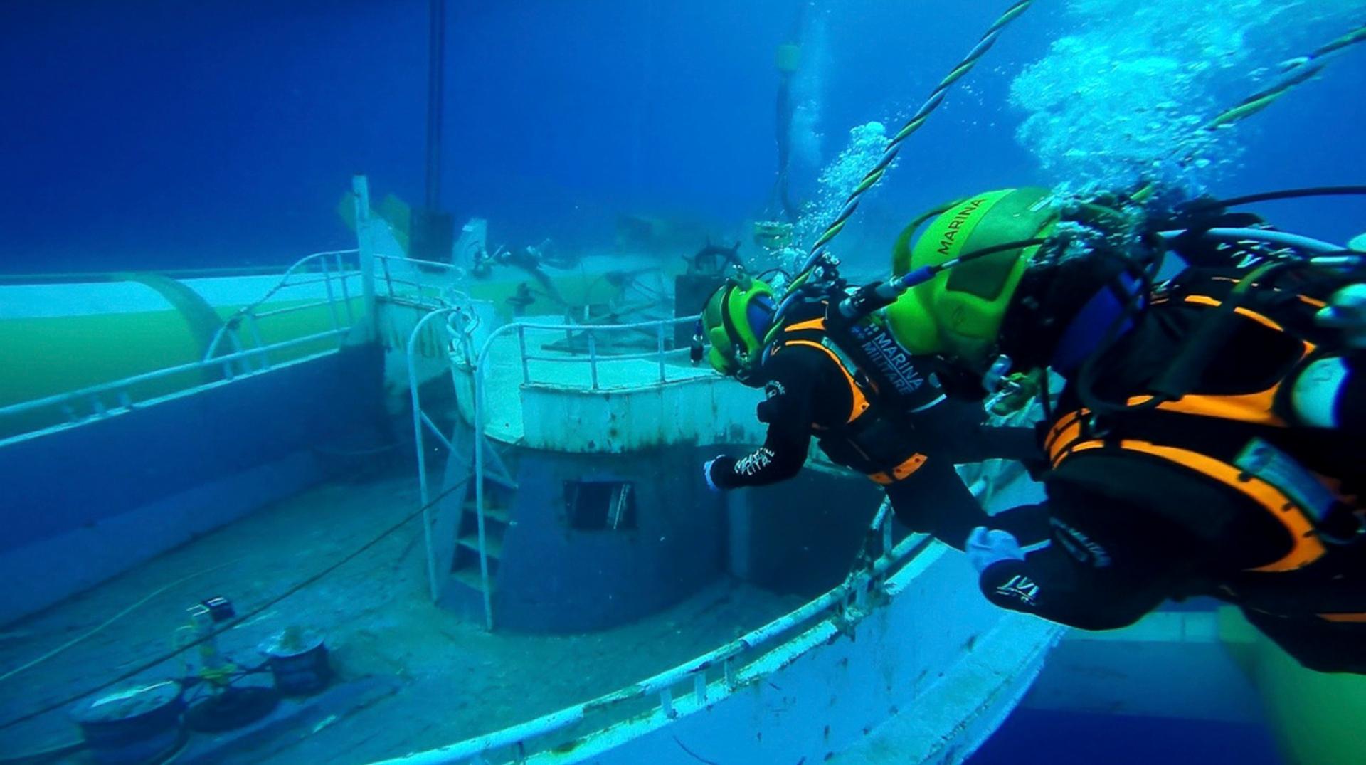 Divers check the boat before it is lifted in the specially made cradle