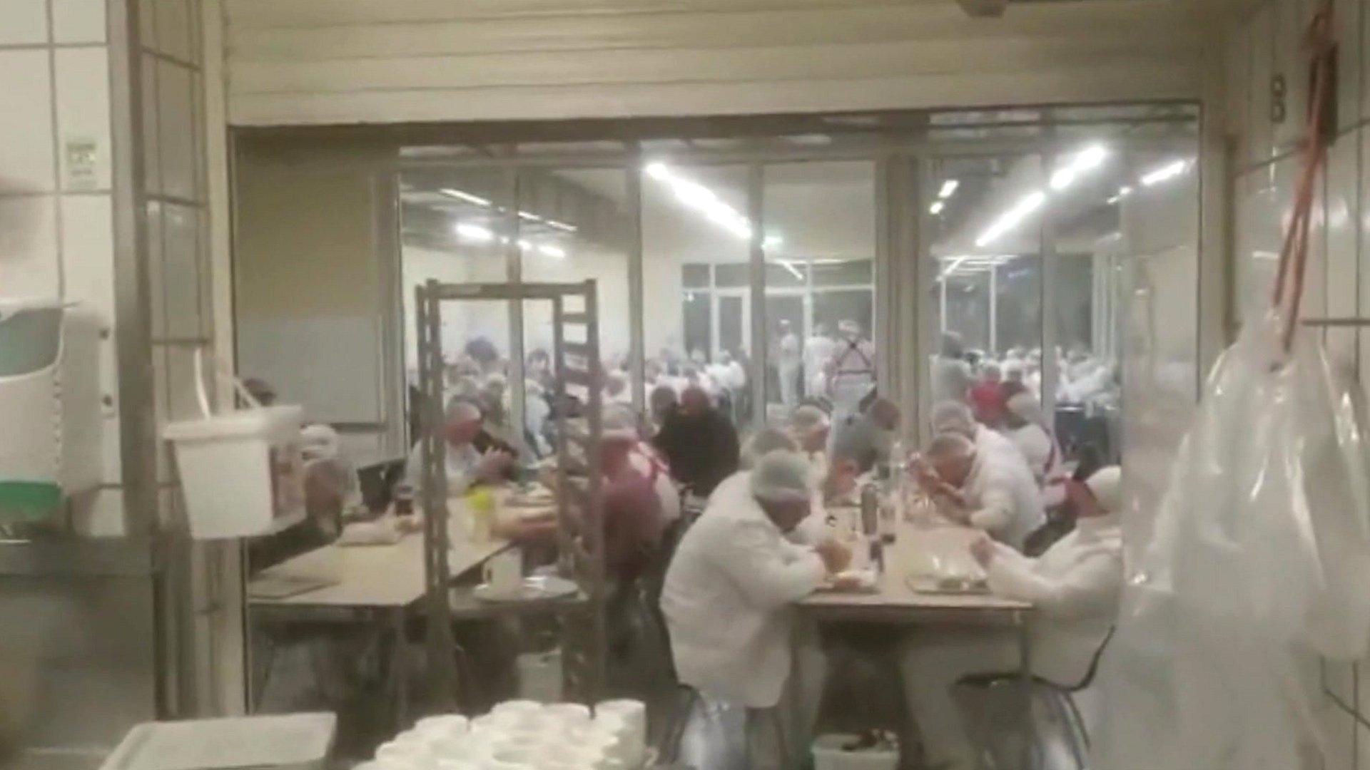 Footage from inside the canteen shows workers sitting together without social distancing