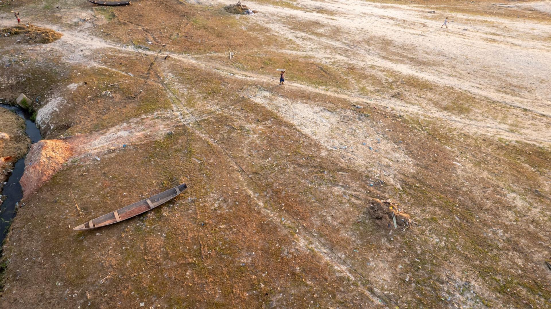 A canoe rests on the bank of a dried-out creek